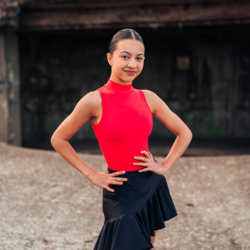 dancer posing in a red leotard and black skirt